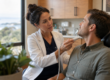 A dentist explains a minimally invasive treatment to a relaxed male patient in a warmly lit dental suite.
